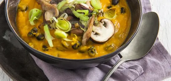 Recept van het Voedingscentrum: Pompoensoep met zwarte bonen en gebakken paddenstoelen